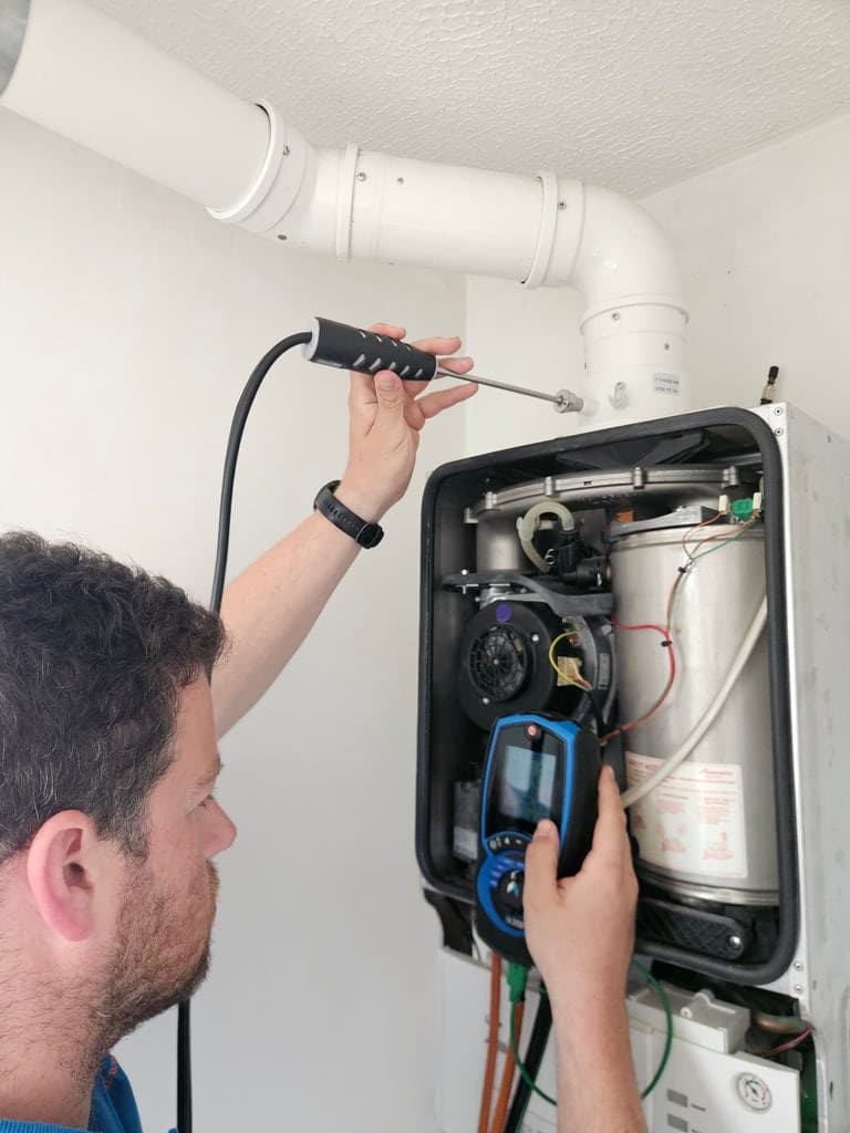 Engineer carrying out flue gas analysis during an annual boiler service in Torquay