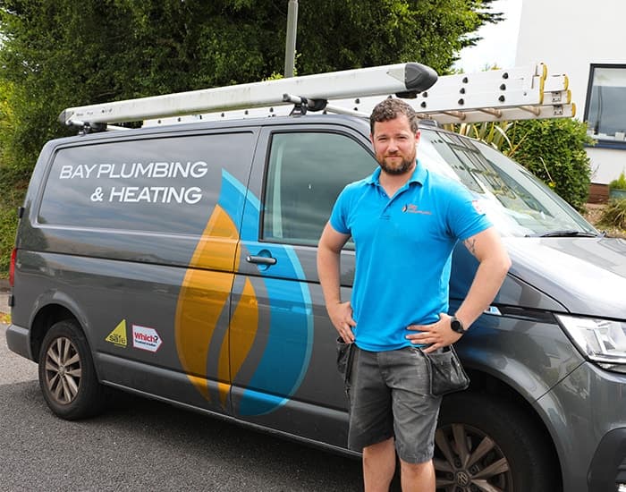 Sean from Bay Plumbing and Heating beside the company van in Torquay